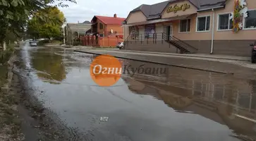 Огромная лужа на улице 8 Марта города Кропоткина затрудняет проезд автомобилей