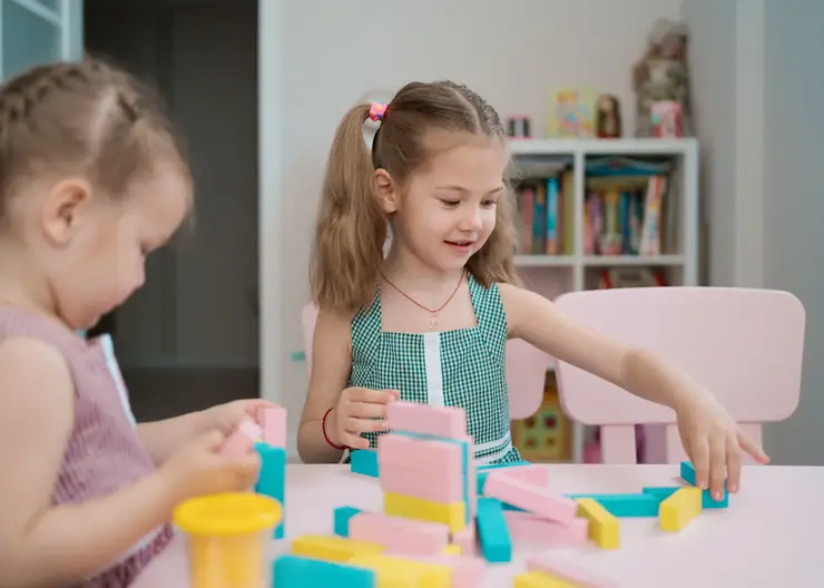 beautiful-caucasian-girls-playing-with-wooden-multi-colored-blocks