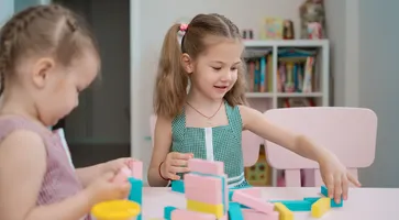 beautiful-caucasian-girls-playing-with-wooden-multi-colored-blocks
