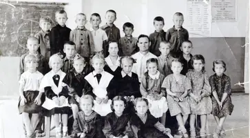1955 год, 1Б класс Темижбекской средней школы № 9 имени В.И. Ленина. В центре Марфа Ивановна Криворучко и Алексей Прохорович Евса, я - второй слева в последнем ряду