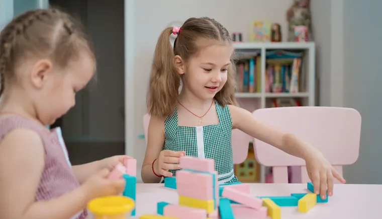beautiful-caucasian-girls-playing-with-wooden-multi-colored-blocks