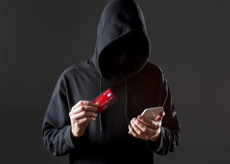 front-view-male-hacker-holding-smartphone-credit-card