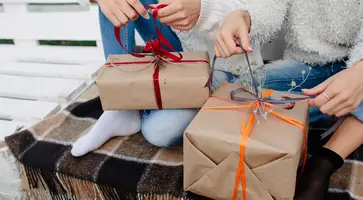 two-beautiful-women-sitting-bench-holding-their-hands-gifts-close-view (1)