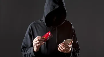 front-view-male-hacker-holding-smartphone-credit-card